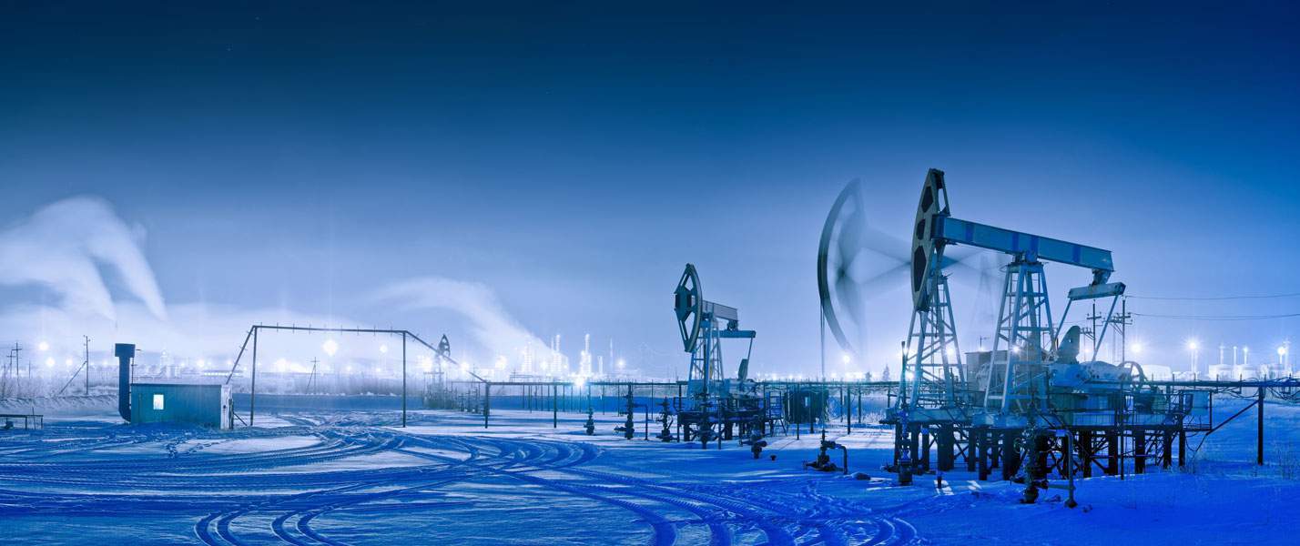 Winter night panoramic oil pumpjack.