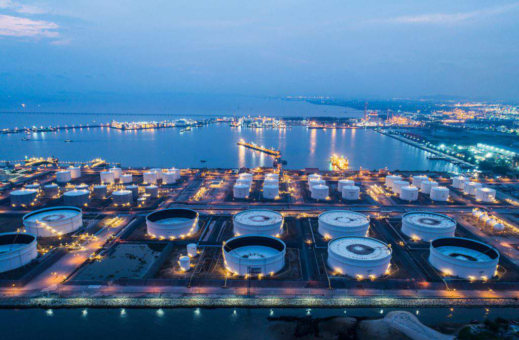 Aerial view or top view night light oil terminal is industrial facility for storage of oil and petrochemical. oil manufacturing products ready for transport and business transportation.